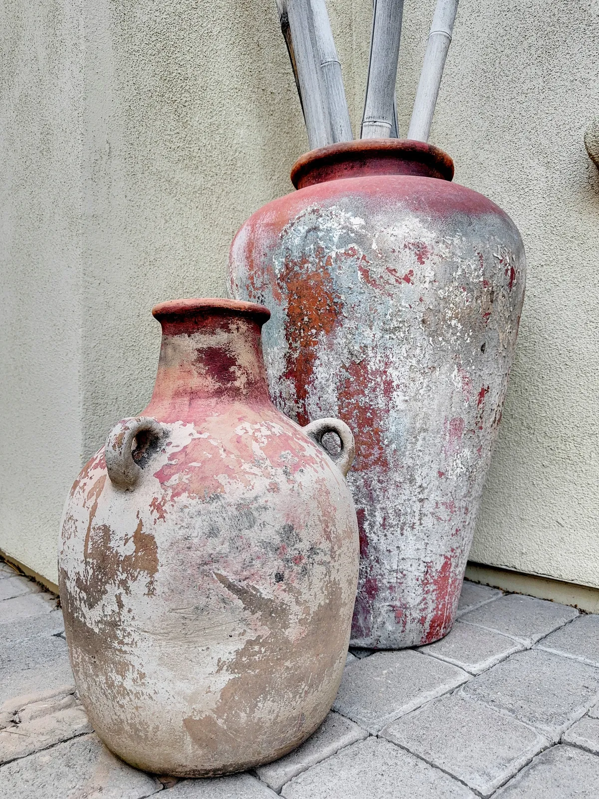 A serene exterior featuring two large decorative pots with bamboo sticks, set against a tranquil backdrop. The scene evokes the peacefulness of outdoor spaces and encourages visitors to imagine enjoying the fresh air with their pet.